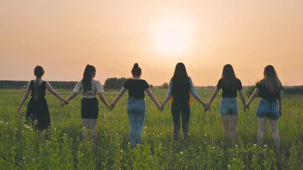 Girls Friends Raise Their Hands at Sunset