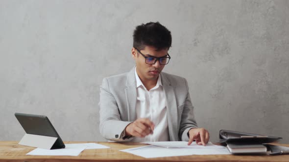 Positive Indian businessman working with paper document