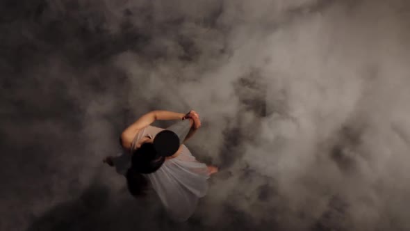 Girl Dancing on a Pole in the Dark Smoke Studio. Black Smoke Background. Top View