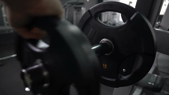 Trainer Putting and Removing Weight Plates From Barbell, Preparing Gym Equipment