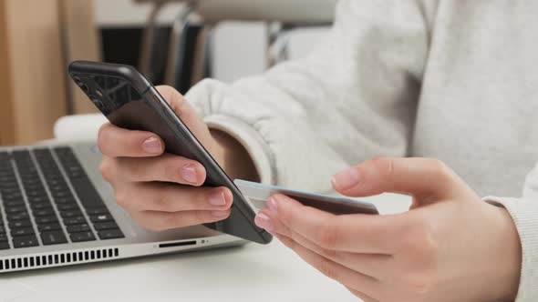 Woman Holding Credit Card and Paying By Mobile Phone