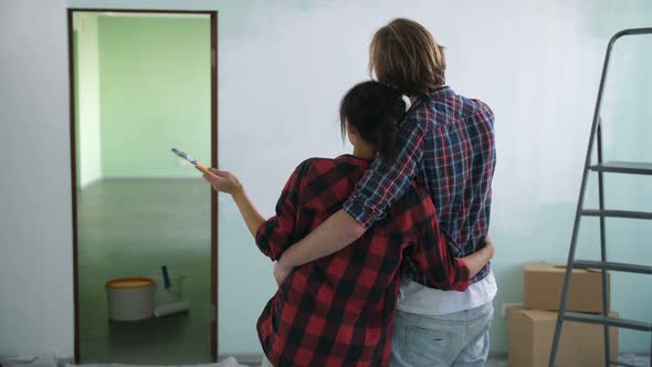 Couple in Love Embrace Looking at Painted Wall