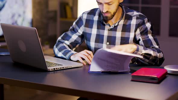 Young Entrepreneur Working on Laptop and Signing Documents