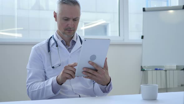 Doctor Using Tablet for Browsing Internet