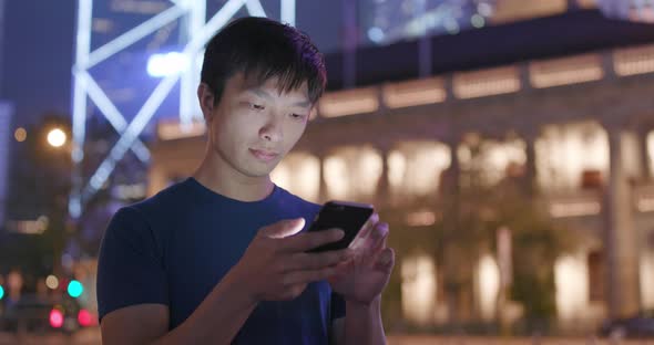 Young Man use of smart phone in city at night