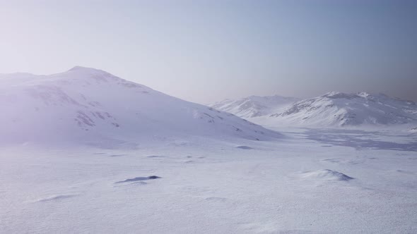 Aerial Landscape of Snowy Mountains and Icy Shores in Antarctica alt