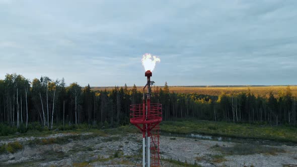 A Drone Descends Over a Burning Torch at an Oil Field in the Swamps of Siberia