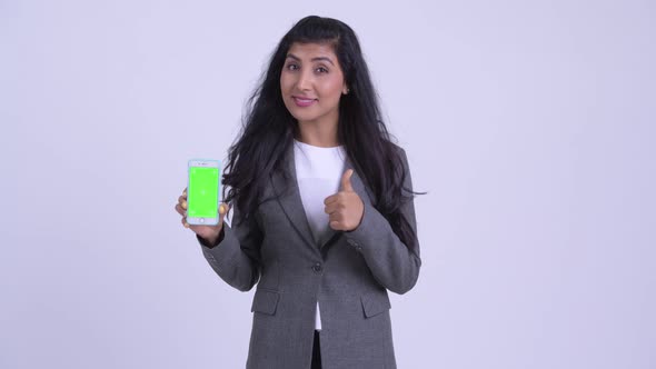 Young Happy Persian Businesswoman Showing Phone and Giving Thumbs Up