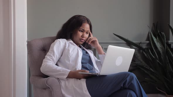 African American Doctor Woman Conducts Videoconference with Patient