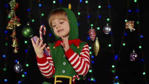 Kid Girl Christmas Elf Santa Helper Types Something on Mobile Phone Enjoys Browsing Social Media