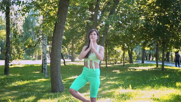 Meditating Outdoors Beautiful Young Yogi Woman Enjoying Relaxing on a Green Meadow in Sunny Weather