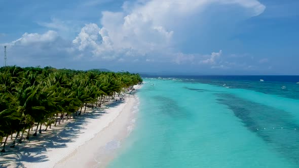 aerial take off along beautiful shore line of turquoise blue sea and palm trees on White beach, Pang