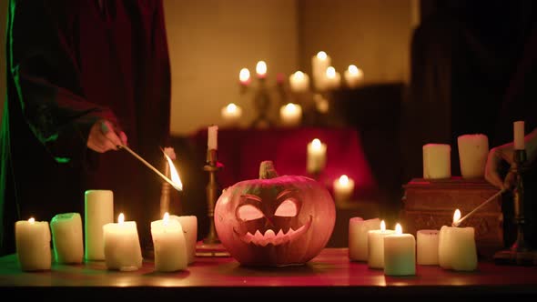 Lighting Candles Near Carved Pumpkin Closeup