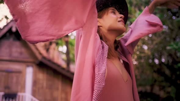 Young Red Haired Woman in Pink Kimono Whirls in a Dance on Tropical Paradise