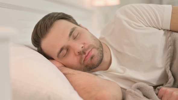 Portrait of Peaceful Young Man Sleeping in Bed