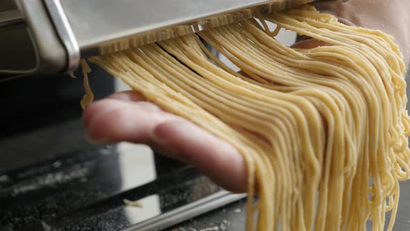 Pasta machine and Italian spaghetti 4K 2160p 30fps UltraHD footage - Dough made  cylindrical solid p