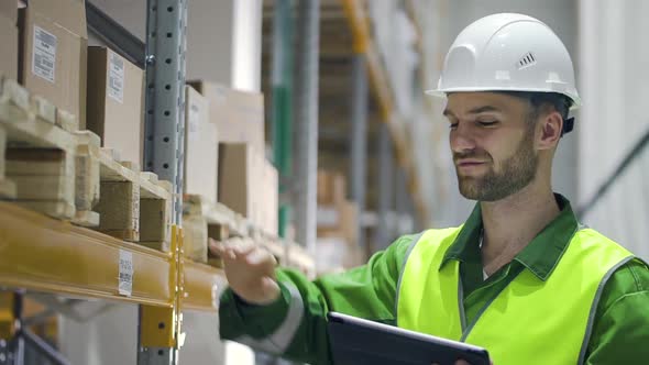 Young Caucasian Man Using Tablet Computer While Working at Warehouse of Modern Company.