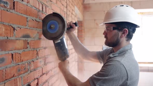 A construction worker with a circular saw in construction site.