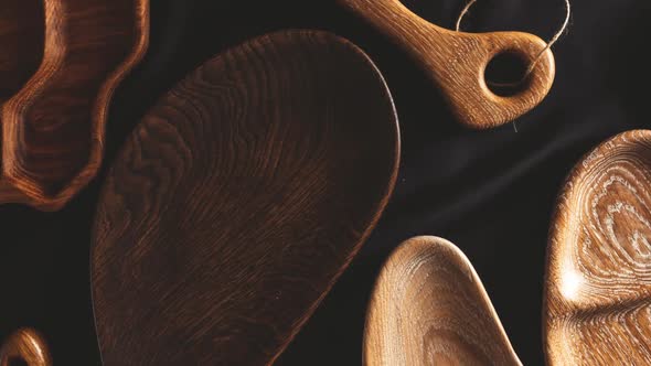 Rich Variety of Wooden Empty Cutting Boards and Plates on Dark Background.