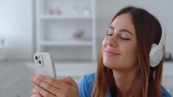 Close Up Woman in Headphones Listening Music in Kitchen Background