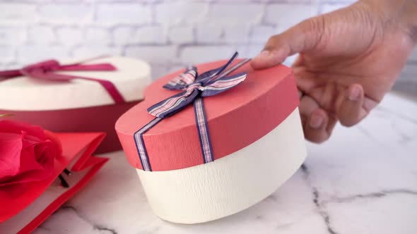 Top View of Man's Hand Holding a Gift Box on Table