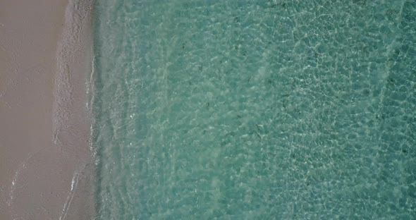 Wide angle overhead clean view of a white sand paradise beach and turquoise sea background 