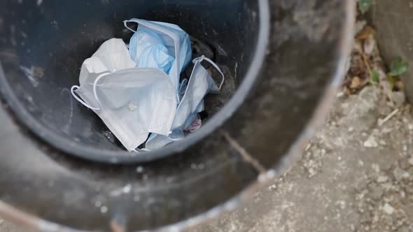 Top View of Thrown Away Medical Face Masks in Trash Bin