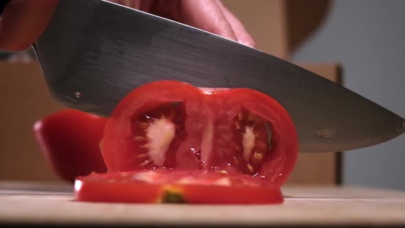 Close up of slicing fresh tomato, slow motion.