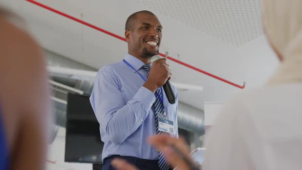 Male speaker addressing applauding audience at a business seminar