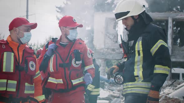 Paramedics Speaking with Rescuer After Disaster