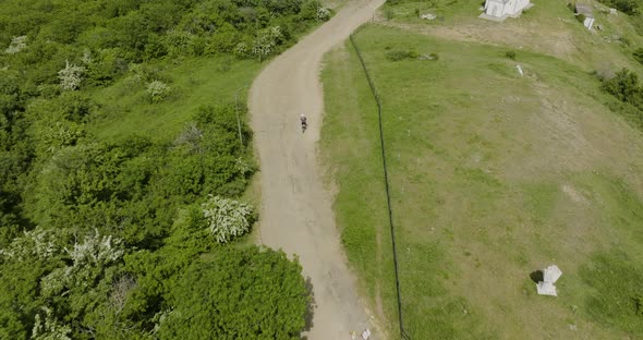 Motorcycle emerging from the forest and driving on an off-road trail in Kojori.