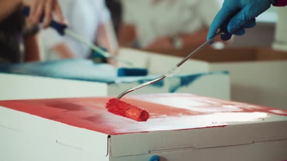 Women Paint White Surfaces with Multicolored Paints