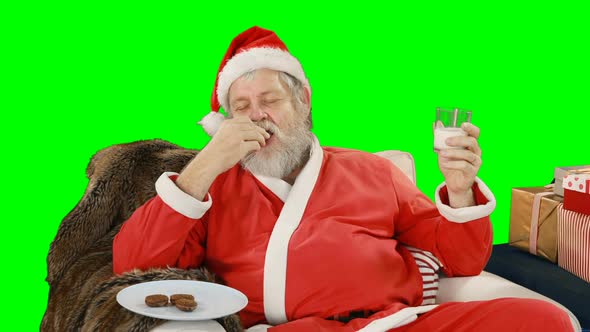 Santa claus relaxing on couch and having sweet food