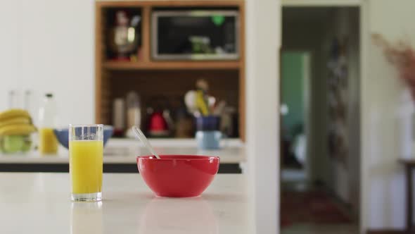 Close up of red bowl and glass of juice on countertop in kitchen