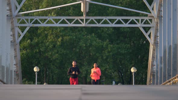 A couple running across a bridge