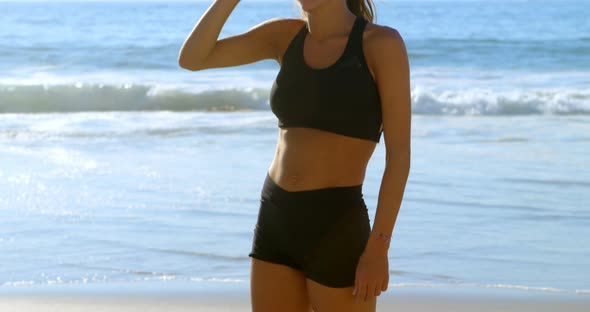 Fit woman standing in the beach 