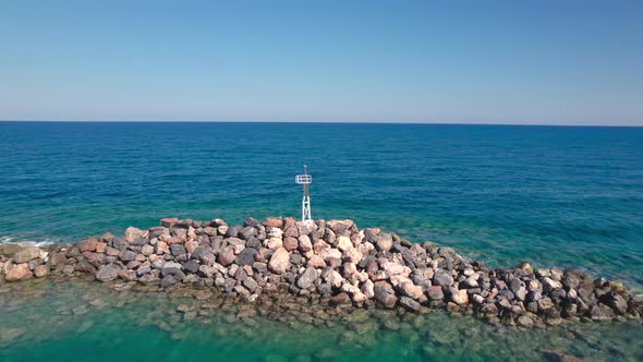 Young Woman Walking on a Stone Breakwater Summer Vacation and Travel Season in Greece