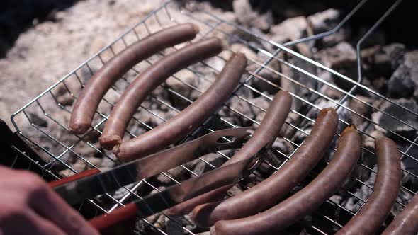 Closeup View of Tasty Sausages Grilling on Charcoal Grill Grate