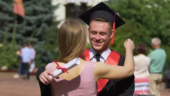 Young Woman Congratulating and Hugging Her Graduate Boyfriend, Happy Moments