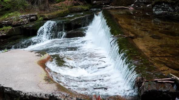 View of a small forest waterfall from a mountain river