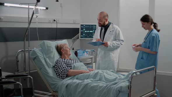 Doctor and Nurse Doing Consultation with Oximeter for Ill Woman