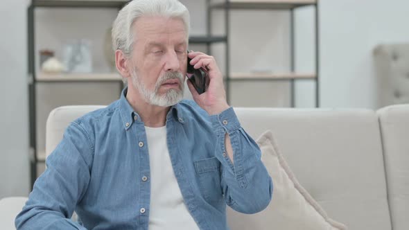 Old Man Talking on Smartphone While Sitting on Sofa