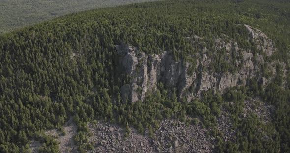 Aerial Drone Shot Flying By Rocky Cliff On Mountain Side