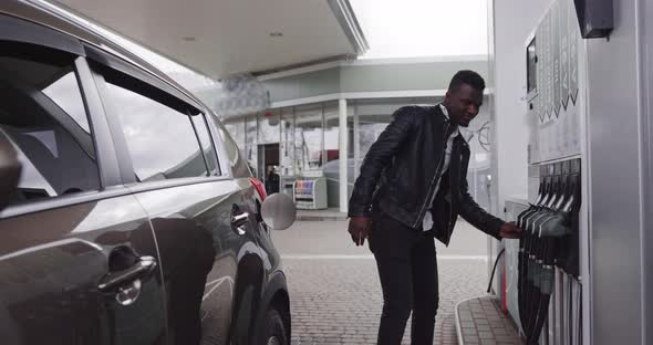 Young Handsome African Bearded Guy in Stylish Casual Outfit Refueling His Luxury