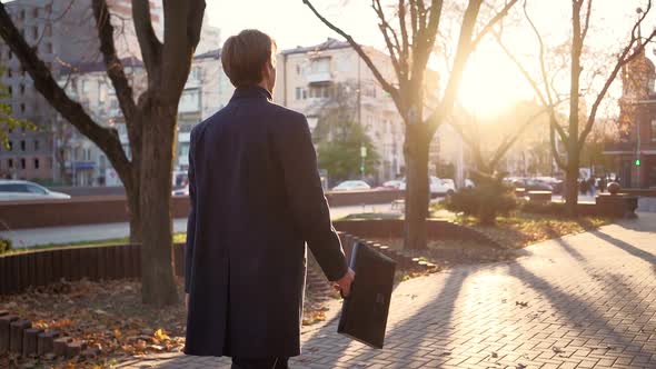 Serious Handsome Business Man Walks After Work in the Sunset Light of the City.