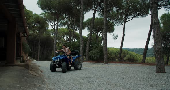 Authentic Footage of Young Beautiful Woman Driving the Quad Bike with Her Son