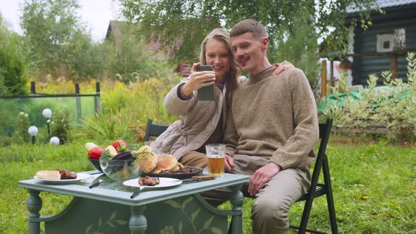 Blonde Woman and Her Husband Take a Selfie on Their Smartphone on Their Wedding Anniversary, They