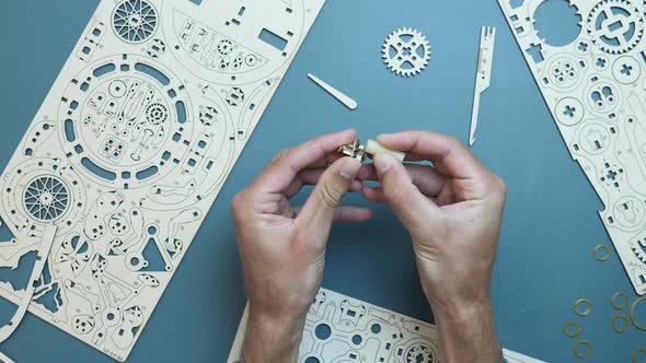 Man hands using wax, assembling wooden small toy details.