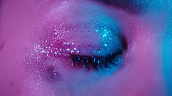 Closeup of Crying Brown Eye Shiny Eye Shadows on the Eyelids Smeared Mascara Watery Eye of Young