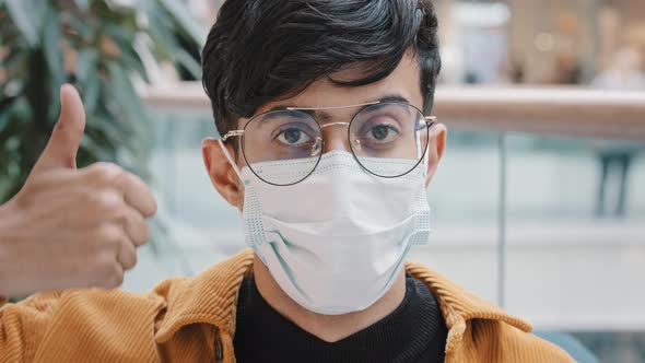 Male Portrait Happy Young Guy in Medical Protective Mask Looks at Camera Nods Head Agreement Sign